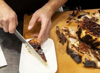 Los Angeles Times-ek AEBetan arrakasta izaten ari den Gazta-Pastelaren sekretuak aireratzen ditu (errezetarekin) Chef Dave Beran cutting and plating a slice of a chilled burnt Basque cheesecake. (Ricardo DeAratanha / Los Angeles Times)