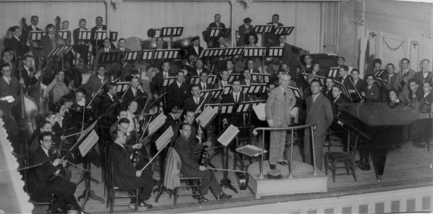 Maurice Ravel con Pablo Sorozábal y la Orquesta Sinfónica de Bilbao en la sala de la Sociedad Filarmónica de Bilbao (1928) Original: Archivo Familia Sorozábal. Procedencia: Fundación Eresbil-Archivo de Compositores Vascos